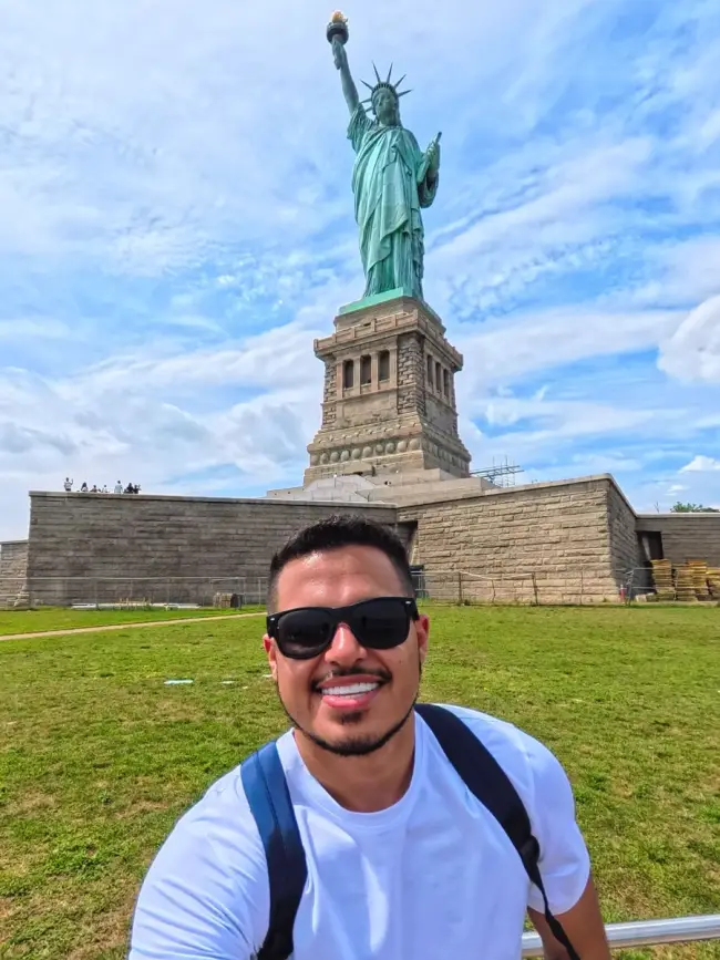 Claudio, fundador do Minha Viagem Pronta, em frente à Estátua da Liberdade em Nova York